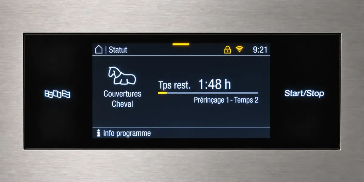 Écran de commande de la machine à laver professionnelle Miele : programme « Couvertures Cheval », prérinçage en cours
